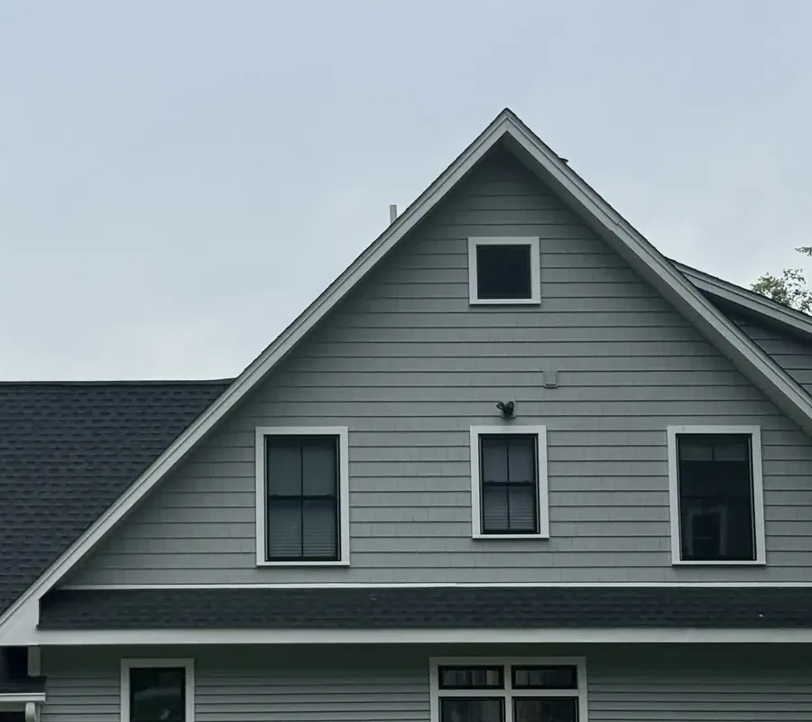 Black-framed windows with white trim across the gabled elevation of a two-story home