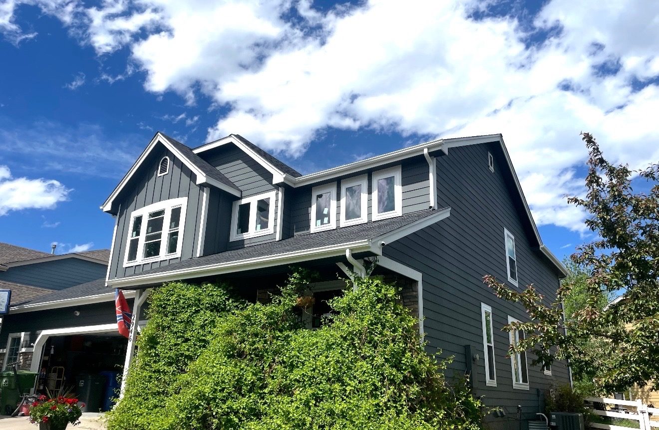 White-trimmed replacement windows on a charcoal-sided two-story Colorado home